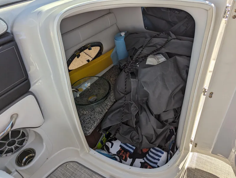 Slide: The Image of 2023 Crownline 260 SS boat storage compartment with various items and accessories inside. - 25