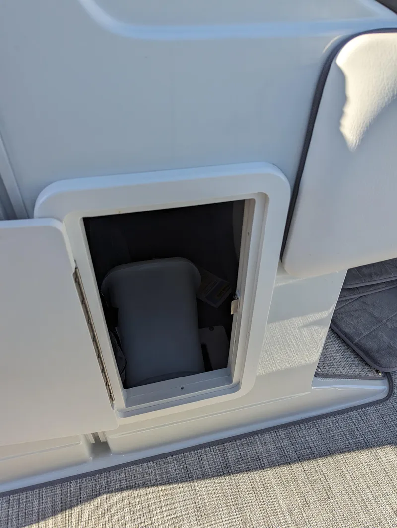 Slide: The Image of 2023 Crownline 260 SS boat storage compartment with open hatch, showcasing interior space. - 32