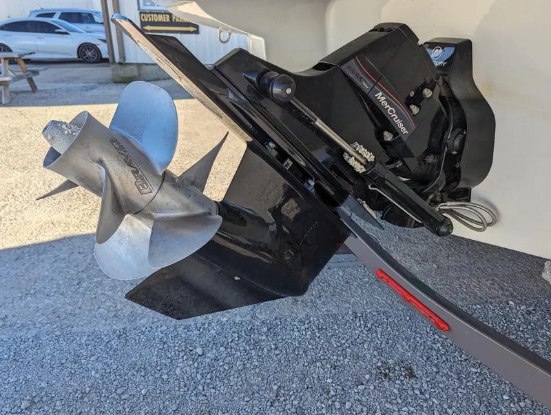Slide: The Image of 2023 Crownline 260 SS boat propeller and outdrive on gravel surface. - 43
