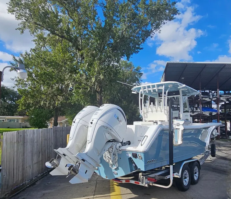 Slide: The Image of 2025 Sea Hunt Gamefish 28 CB boat on trailer, parked outdoors. - 10