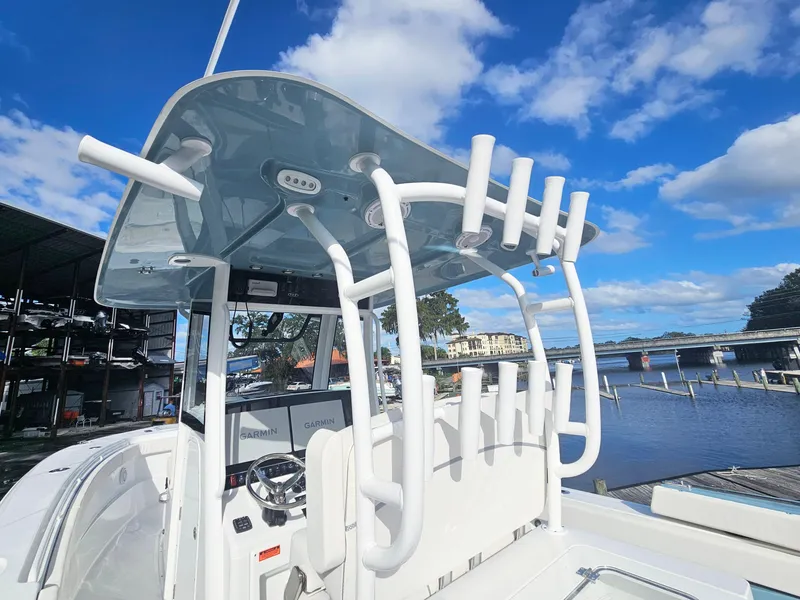 Slide: The Image of 2025 Sea Hunt Gamefish 28 CB boat with rod holders, docked under a clear blue sky. - 11