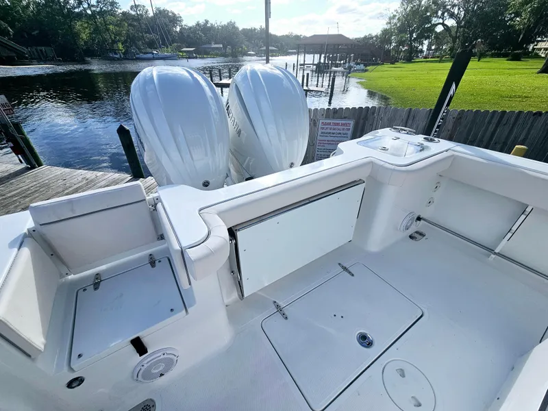 Slide: The Image of 2025 Sea Hunt Gamefish 28 CB boat with dual engines, docked by a scenic waterfront. - 19