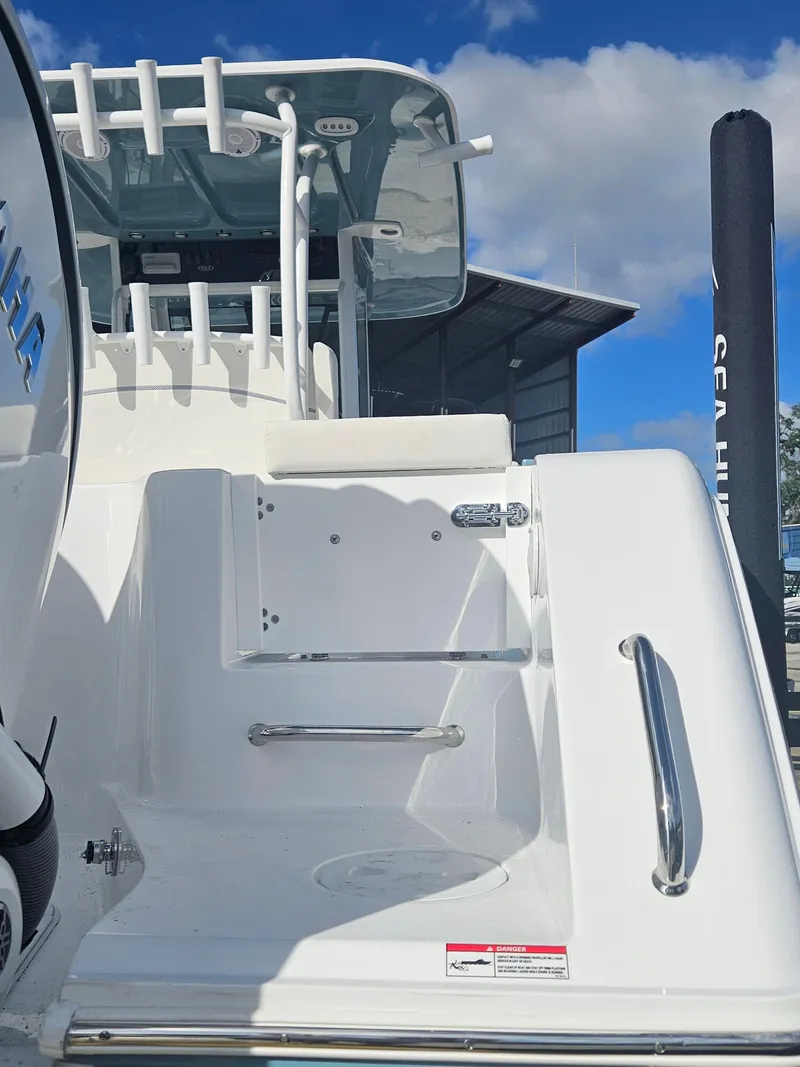 Slide: The Image of 2025 Sea Hunt Gamefish 28 CB boat, white deck, stainless steel handrails, clear blue sky. - 35