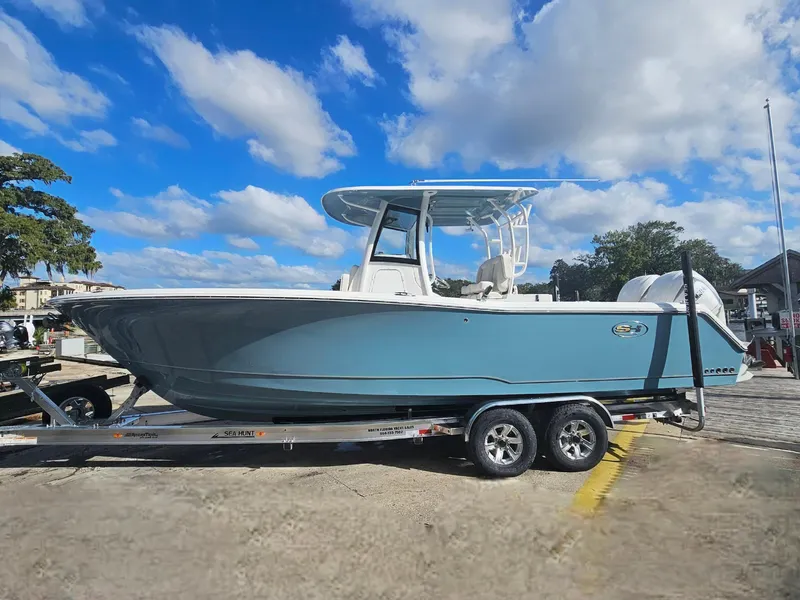 Slide: The Image of 2025 Sea Hunt Gamefish 28 CB boat on trailer under blue sky. - 4