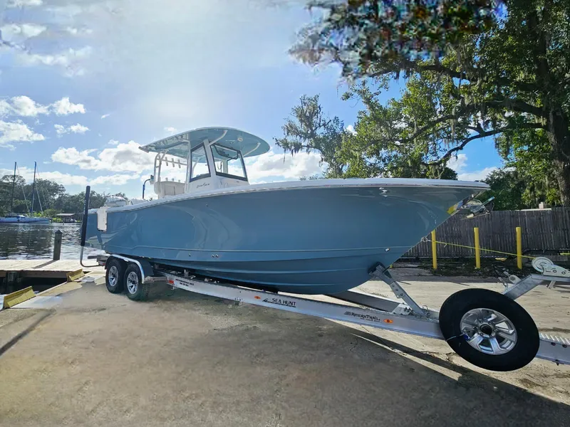 Slide: The Image of 2025 Sea Hunt Gamefish 28 CB boat on trailer, parked outdoors. - 7