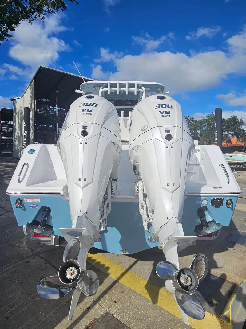 Slide: The Image of 2025 Sea Hunt Gamefish 28 CB with twin 300 HP engines, docked under blue sky. - 9
