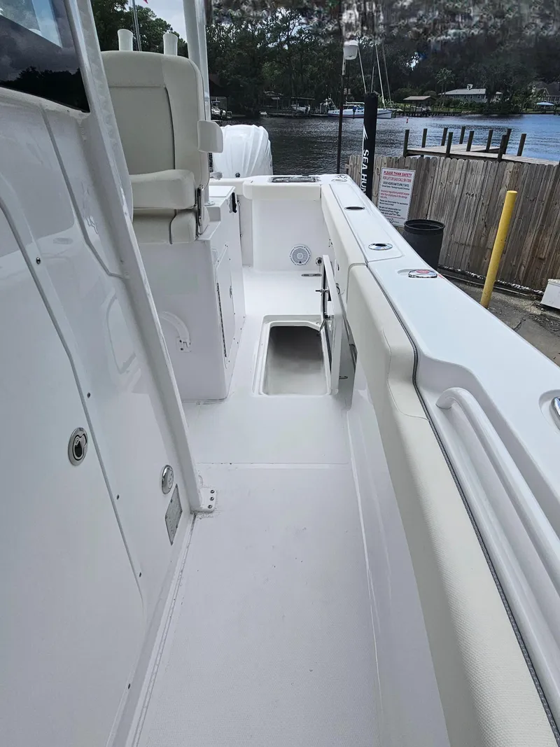 Slide: The Image of 2025 Sea Hunt Gamefish 28 CB boat interior with white seating and deck. - 30