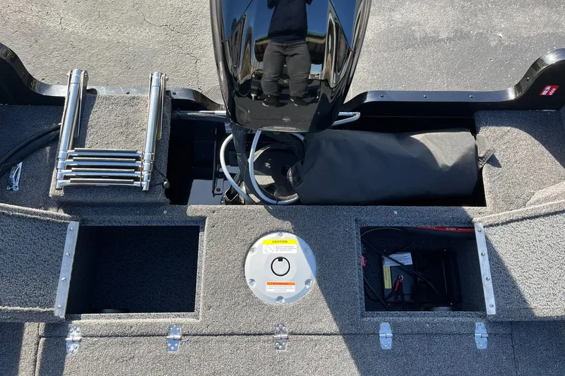 Slide: The Image of 2025 Lund 1650 Rebel XL SS boat interior with storage compartments and motor. - 11