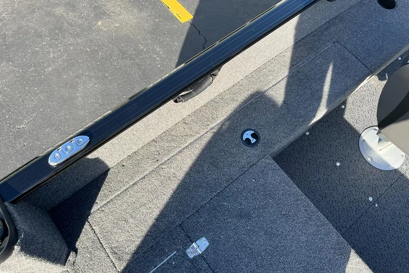 Slide: The Image of 2025 Lund 1650 Rebel XL SS boat interior with gray carpet and seating area. - 20