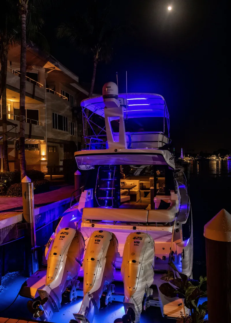 Slide: The Image of 2022 Regal 42 FXO yacht illuminated at night with blue lights. - 20
