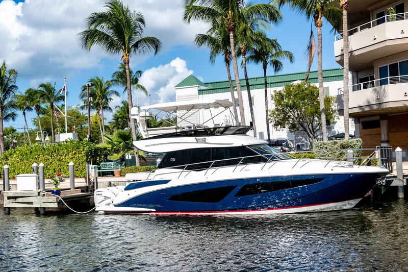 Slide: The Image of 2022 Regal 42 FXO yacht docked by palm trees and buildings. - 24