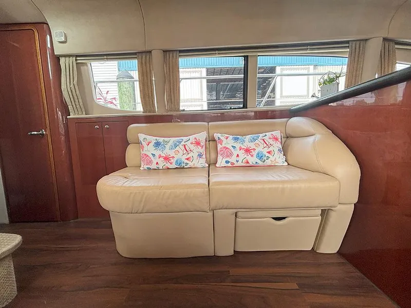 Slide: The Image of Luxurious interior of 2002 Sea Ray 480 Motor Yacht with beige leather sofa and floral pillows. - 15