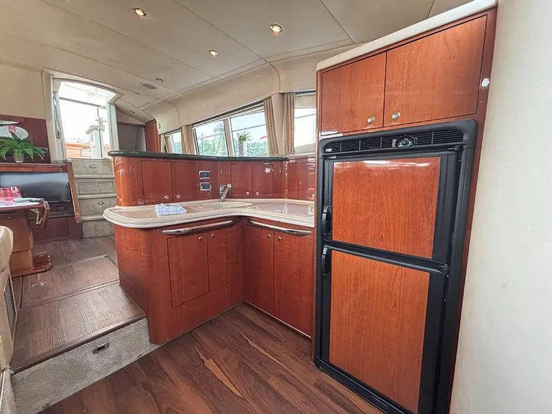 Slide: The Image of Interior of 2002 Sea Ray 480 Motor Yacht with modern kitchen and wood cabinetry. - 17