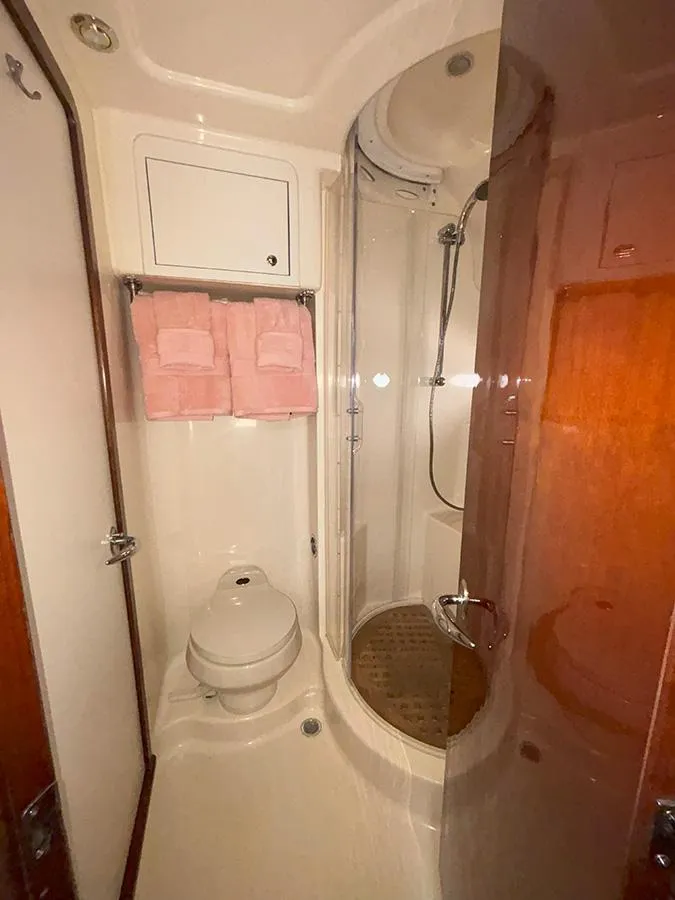 Slide: The Image of 2002 Sea Ray 480 Motor Yacht bathroom with shower, toilet, and pink towels. - 26
