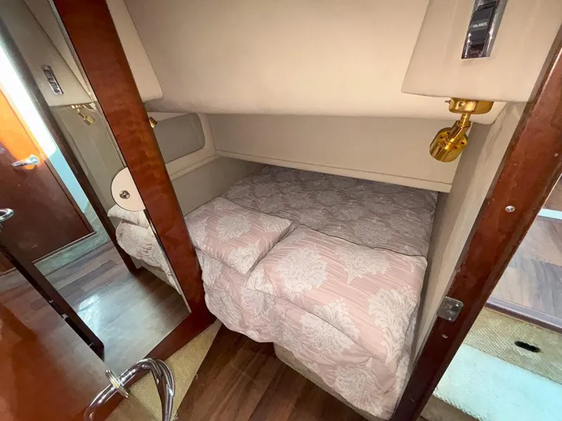 Slide: The Image of 2002 Sea Ray 480 Motor Yacht cabin with cozy bed and elegant wood finish. - 29