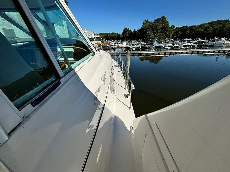 Slide: The Image of 2002 Sea Ray 480 Motor Yacht docked at a marina, reflecting on calm water. - 3