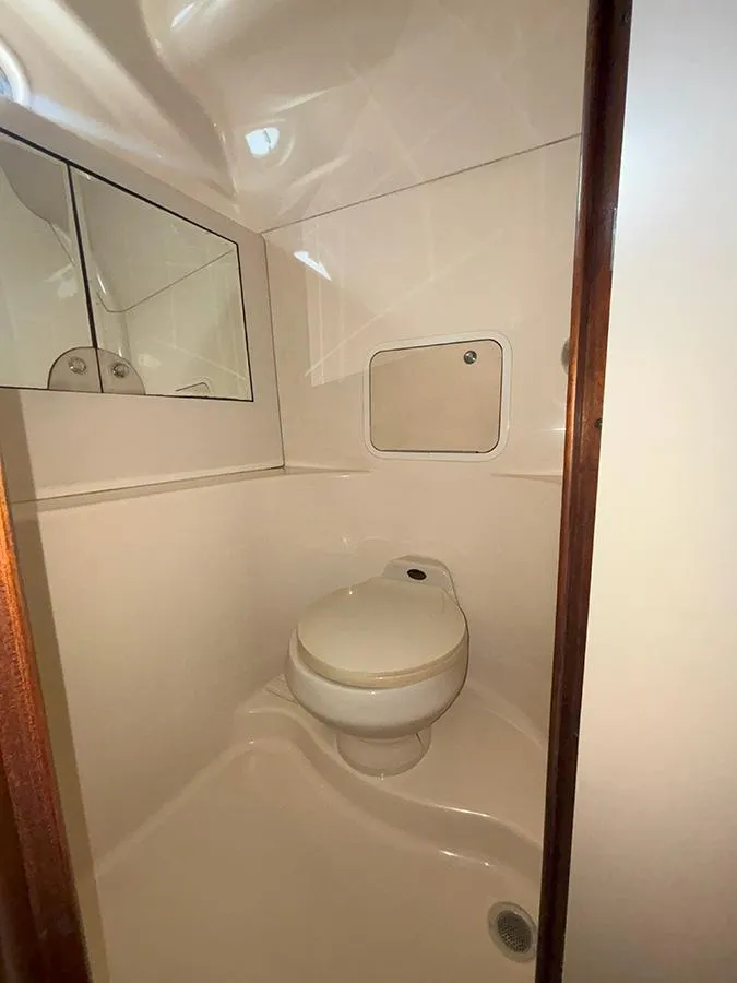 Slide: The Image of 2002 Sea Ray 480 Motor Yacht bathroom with toilet and mirrored cabinet. - 36