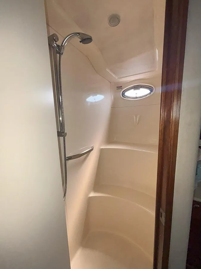 Slide: The Image of 2002 Sea Ray 480 Motor Yacht shower with handheld showerhead and porthole window. - 37