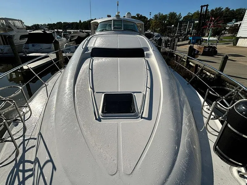 Slide: The Image of 2002 Sea Ray 480 Motor Yacht docked, showcasing sleek deck design and marina surroundings. - 4