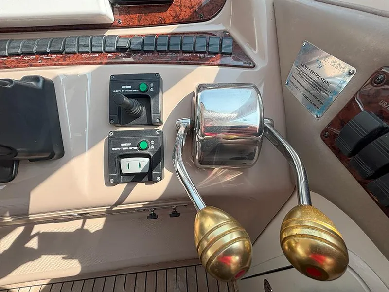 Slide: The Image of Control panel of 2002 Sea Ray 480 Motor Yacht with throttle levers and switches. - 44