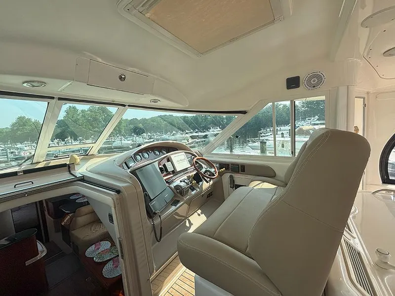 Slide: The Image of 2002 Sea Ray 480 Motor Yacht helm with panoramic windows and luxurious seating. - 6