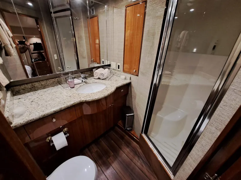 Slide: The Image of Luxurious bathroom in 2006 Hatteras 68 Convertible yacht with granite countertop and glass shower. - 25