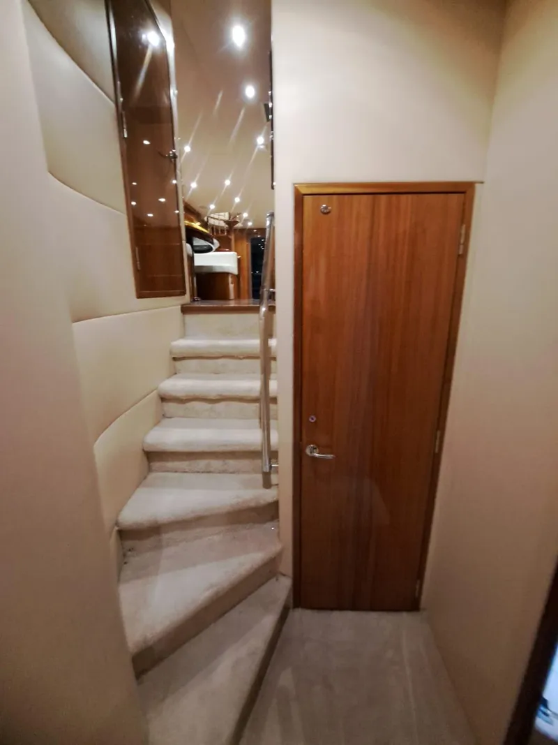 Slide: The Image of Interior staircase of 2006 Hatteras 68 Convertible yacht with wooden door and carpeted steps. - 29