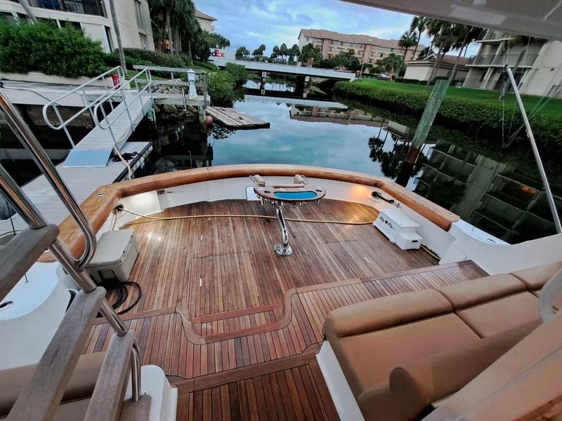 Slide: The Image of Luxurious 2006 Hatteras 68 Convertible yacht with elegant teak deck and serene waterfront view. - 39