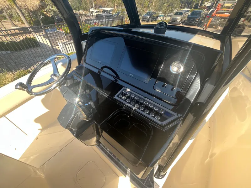 Slide: The Image of 2025 Scout 277 LXF boat dashboard with steering wheel and control panel. - 11