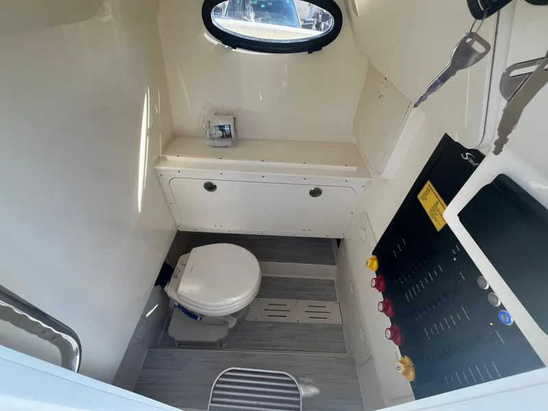 Slide: The Image of 2025 Scout 277 LXF boat interior with toilet and control panel. - 13