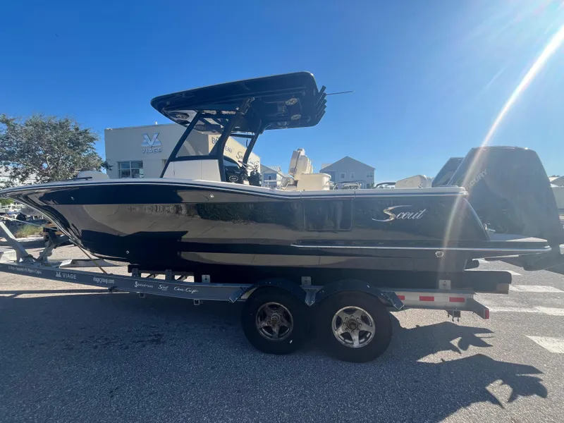 Slide: The Image of 2025 Scout 277 LXF boat on trailer under clear blue sky. - 2