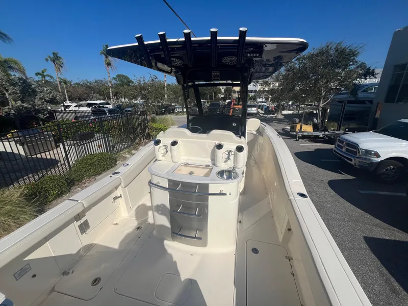 Slide: The Image of 2025 Scout 277 LXF boat with center console and T-top in a sunny outdoor setting. - 4