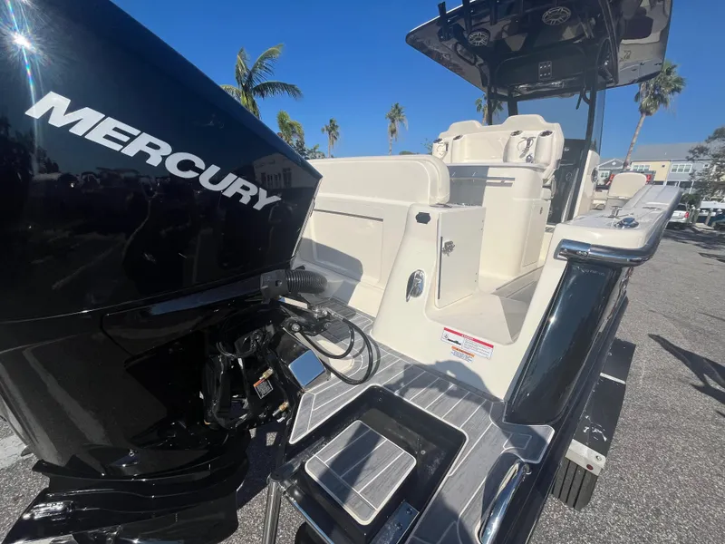 Slide: The Image of 2025 Scout 277 LXF boat with Mercury engine, docked under clear blue sky. - 5