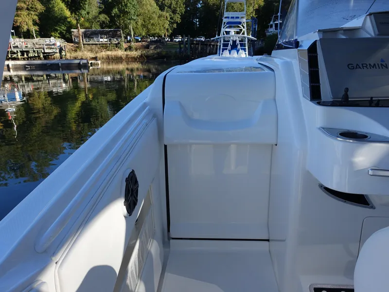 Slide: The Image of 2014 Cigarette 42 Huntress boat deck with Garmin equipment, docked by a serene waterfront. - 10