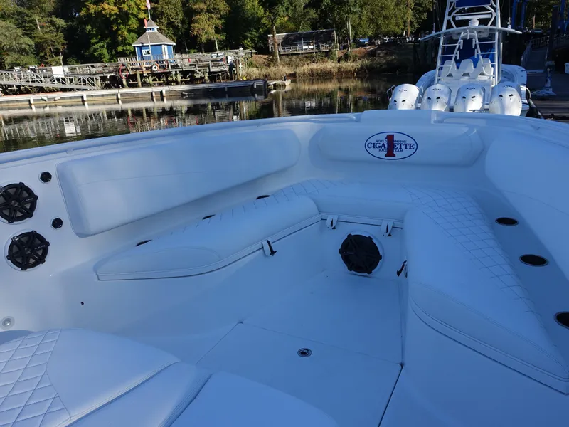 Slide: The Image of 2014 Cigarette 42 Huntress boat with white seating and speakers, docked by a marina. - 11