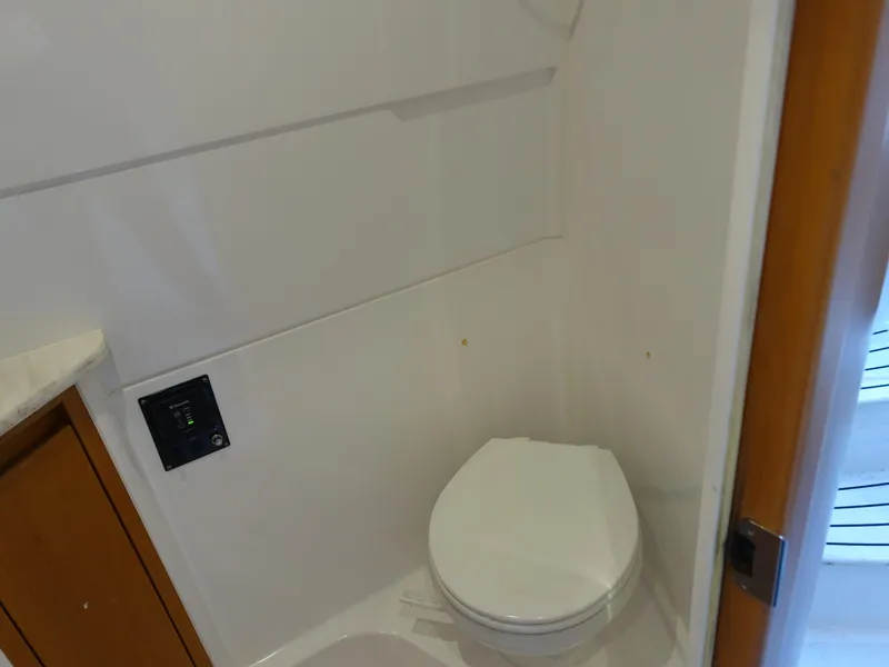 Slide: The Image of 2014 Cigarette 42 Huntress boat bathroom with white toilet and wooden cabinet. - 29