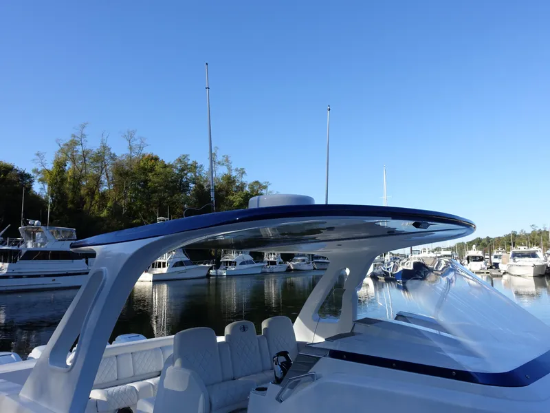 Slide: The Image of 2014 Cigarette 42 Huntress boat docked in a marina under clear blue sky. - 3