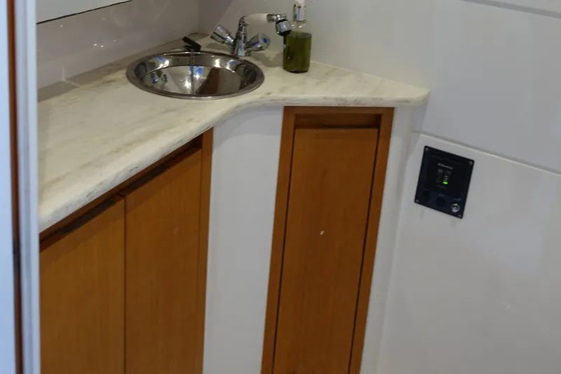 Slide: The Image of 2014 Cigarette 42 Huntress bathroom sink with wooden cabinets and marble countertop. - 30