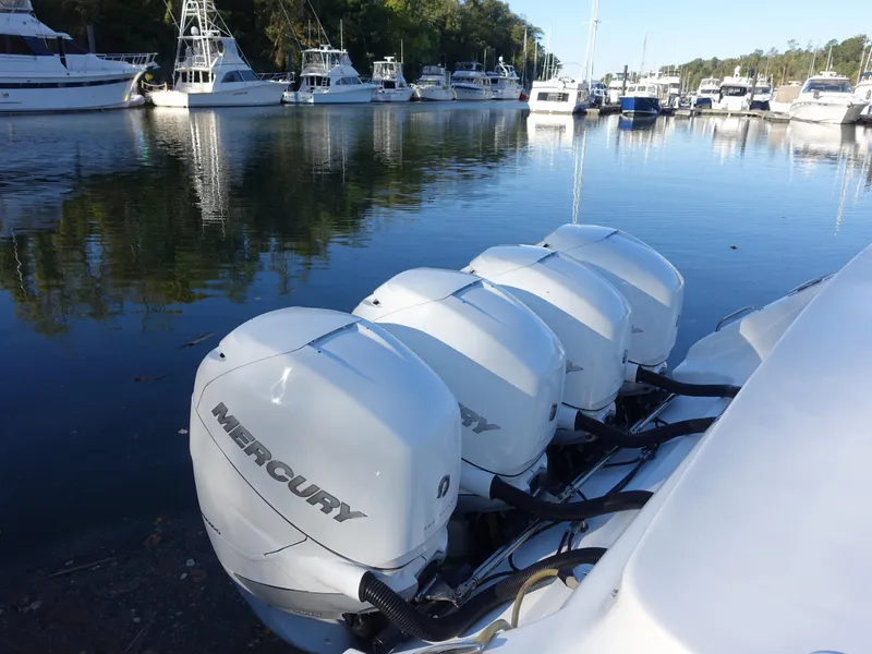 Slide: The Image of 2014 Cigarette 42 Huntress with four Mercury outboard engines docked in a marina. - 31