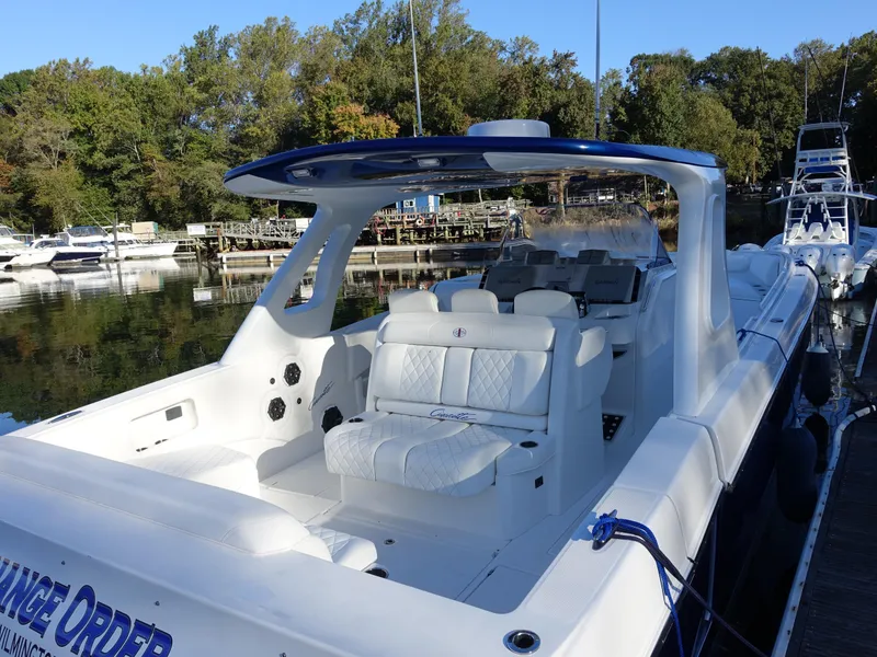 Slide: The Image of 2014 Cigarette 42 Huntress boat docked, featuring sleek white seating and modern design. - 4