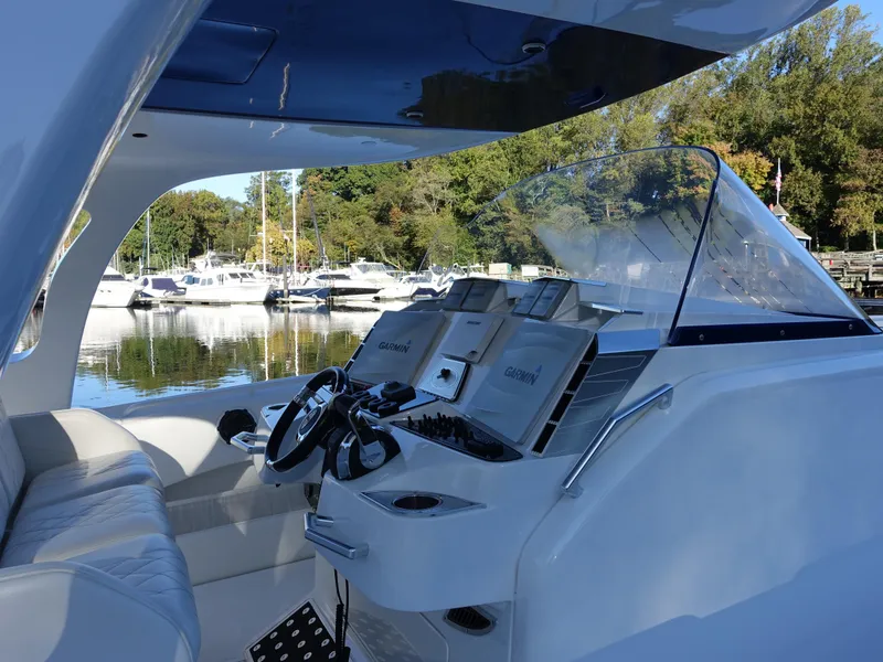 Slide: The Image of 2014 Cigarette 42 Huntress boat interior with modern controls and scenic marina view. - 5