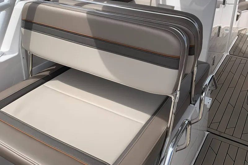 Slide: The Image of 2022 Cutwater C-24 DC boat seating with beige and gray upholstery. - 14