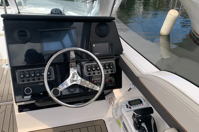 Slide: The Image of 2022 Cutwater C-24 DC boat dashboard with steering wheel and control panel. - 16
