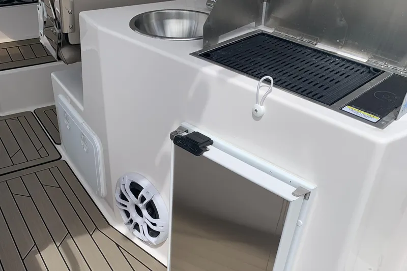 Slide: The Image of 2022 Cutwater C-24 DC boat kitchen with grill, sink, and storage. - 4