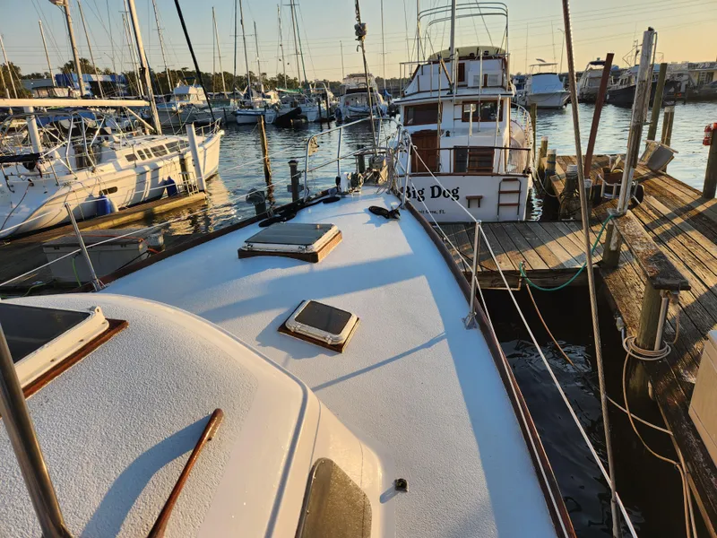Slide: The Image of 1979 Morgan 45 Ketch docked at marina, surrounded by other boats at sunset. - 13