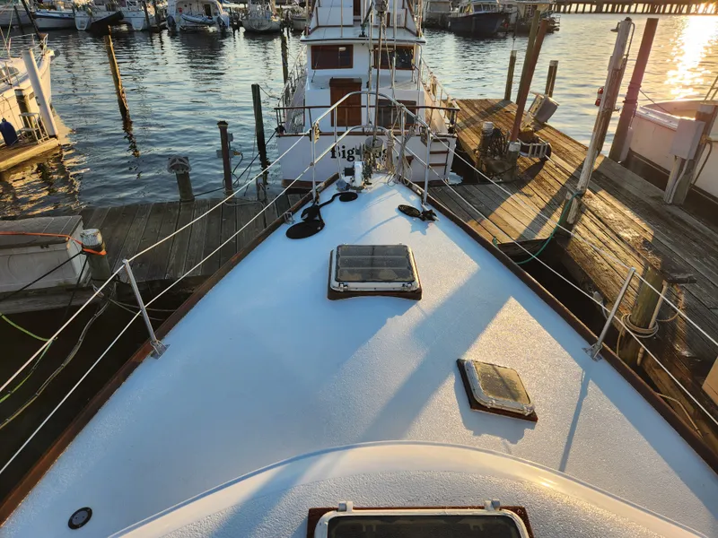 Slide: The Image of 1979 Morgan 45 Ketch sailboat docked at marina during sunset. - 16