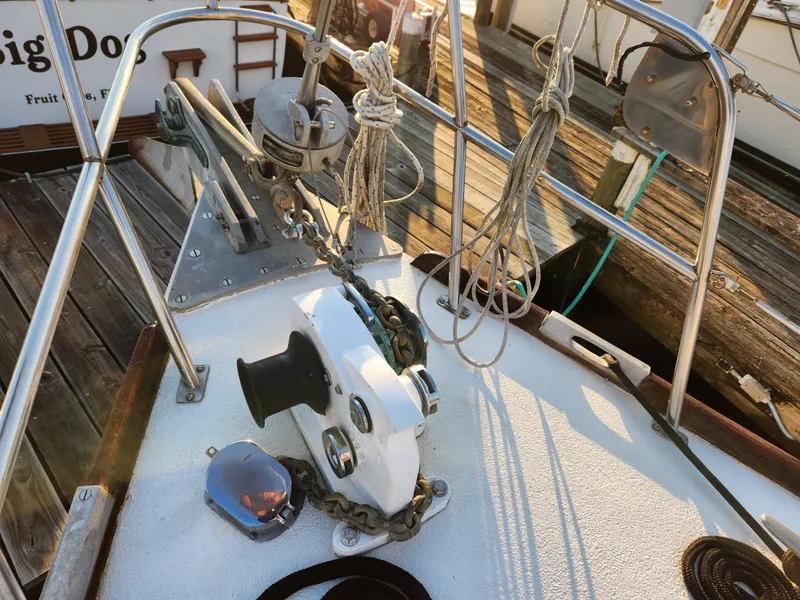 Slide: The Image of 1979 Morgan 45 Ketch sailboat deck with winch and ropes in a marina setting. - 17