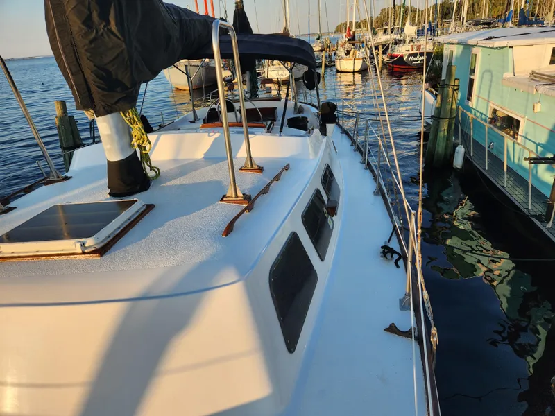 Slide: The Image of 1979 Morgan 45 Ketch sailboat docked in a marina, surrounded by other boats. - 21
