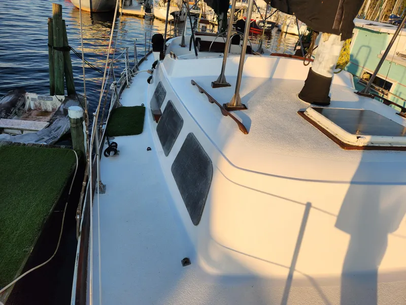 Slide: The Image of 1979 Morgan 45 Ketch sailboat docked, showing deck and cabin details. - 22