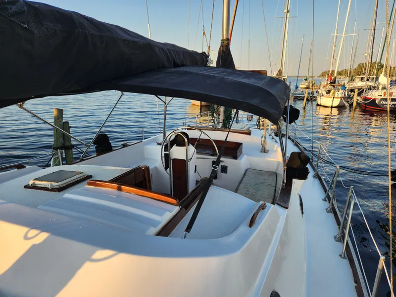 Slide: The Image of 1979 Morgan 45 Ketch sailboat docked in a serene marina setting. - 25